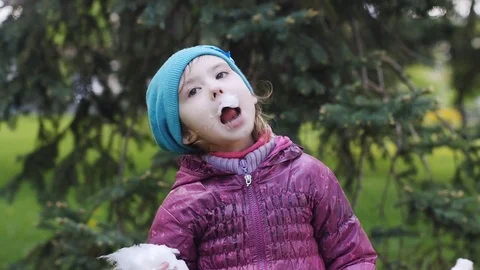 Little girl eating cotton candy on a stick Stock Footage