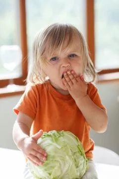 Little girl eats cabbage Foto stock