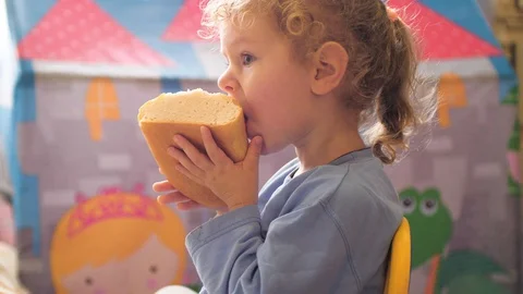 Little girl eats a loaf of bread Stock Footage 127835266