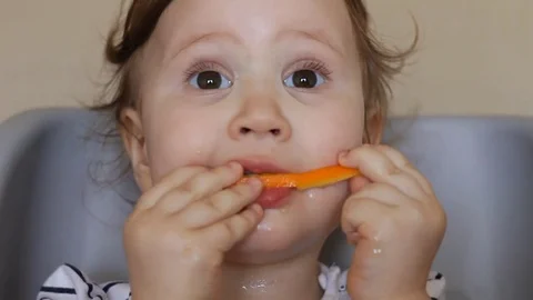 A little girl eats an orange. Stock Footage 73810344