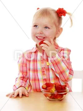 Little girl eats strawberries Stock Photos
