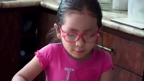 A little girl explaining how she slipped on the floor and hit her face Stock Footage 147874701