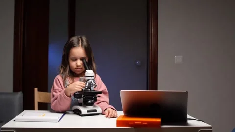 Little girl exploring microworld with microscope during science lesson Stock Footage 319594086