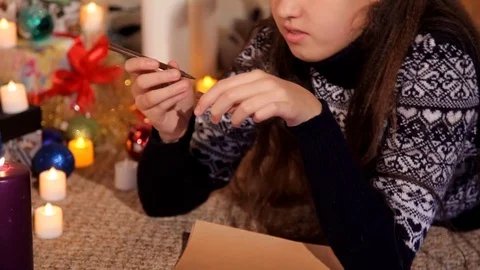 Little girl in a festive setting on a sheet of paper draws a Christmas card Stock Footage 82504341