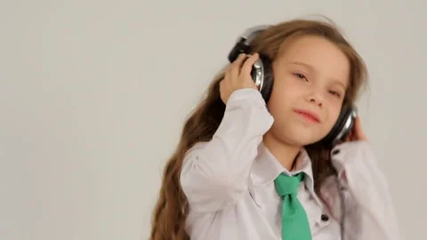 Little girl is fun dancing while listening to music on headphones. Slow motion. Stock Footage 120424246