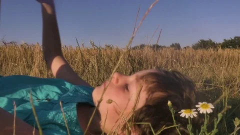 Little Girl get up from the ground in open field Stock Footage