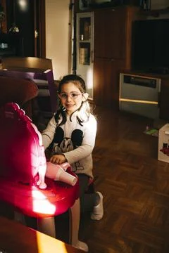 Little girl with glasses playing make-up on a toy dressing table Stock Photos