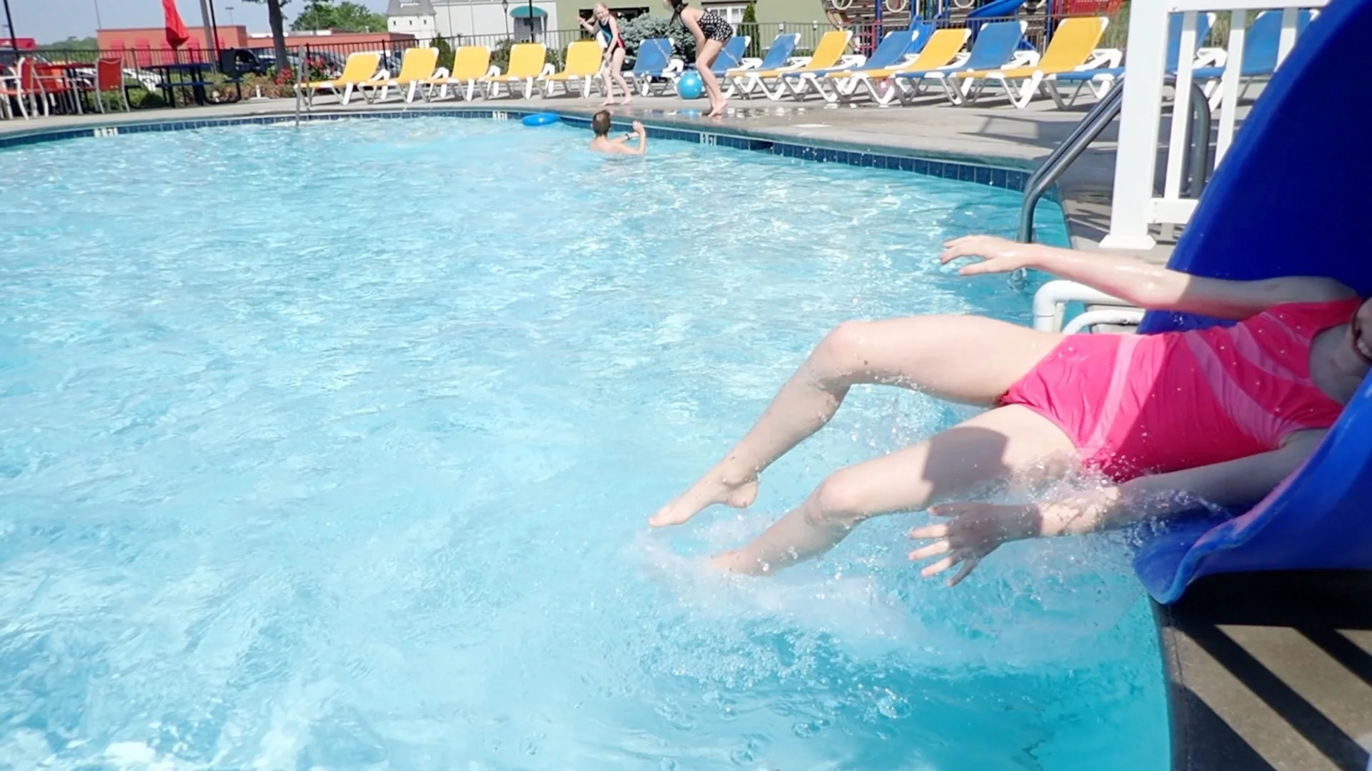 Little girl going down waterslide at swimmingpool