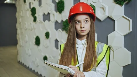 Little girl in hardhat taking notes in notepad Stock Footage 100089842