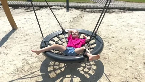 Little girl having fun and enjoy riding swing in outdoors area, front viewpoint Stock Footage 243877053