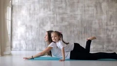 little girl doing yoga with her mom in t, Stock Video