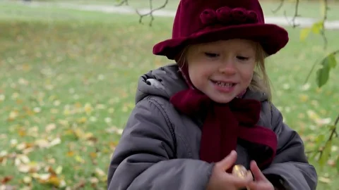 The little girl is holding a garland in her hands. hanging on a tree light bulb Stock Footage