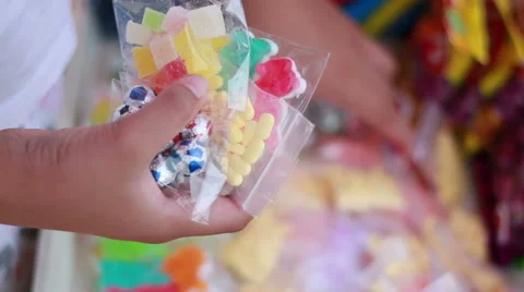 Little girl holds colorful sweet candy in the store Stock Footage