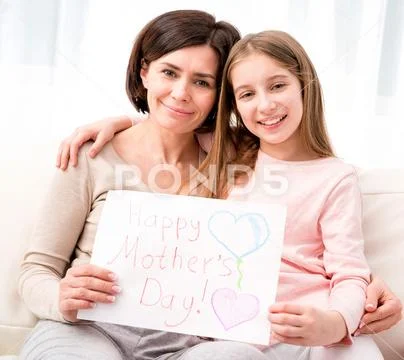 Little girl hugging her mother and holding greating card Stock Photos