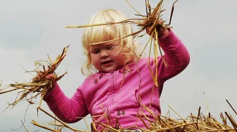 Little girl indulges in a haystack Stock Footage 8911274