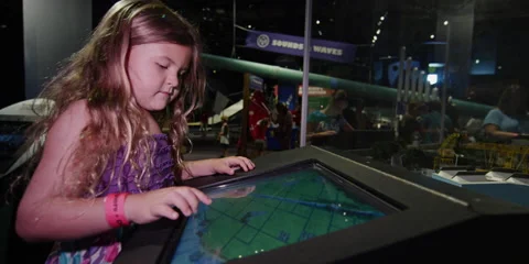 Little girl interacting with a computer screen at a science center Stock Footage 142949766