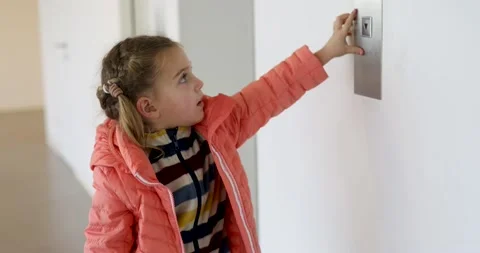 Little girl in a jacket presses the elevator button Video stock 219472424