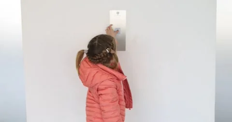 Little girl in a jacket presses the elevator button 스톡 동영상 219611432