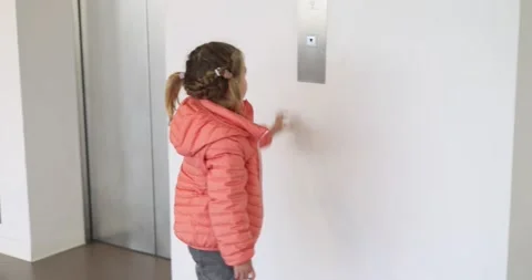 Little girl in a jacket presses the elevator button Stock Footage 219783724