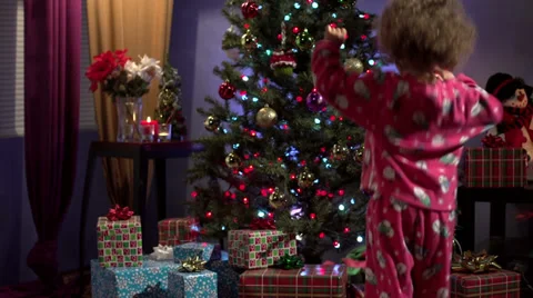 Little girl jumping up and down for Christmas presents - Slow Motion Stock Footage