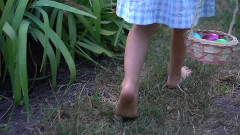 Little girl looking for Easter eggs with basket in hand, entertainment for Stock Footage 168928861