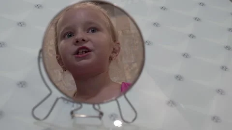 Little girl looking at her reflection in the mirror Stock Footage 343661703