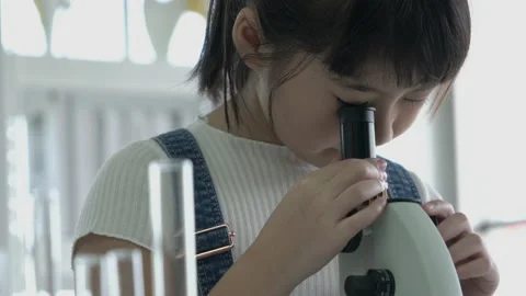 Little girl is looking microscope. Stock-Footage 173598176