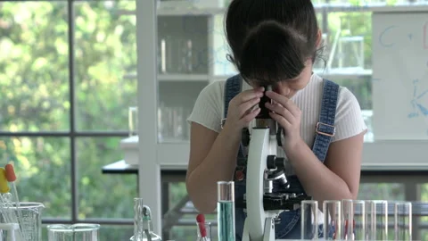 Little girl is looking microscope. Stock Footage 177954907