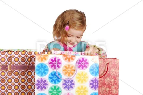 Little girl looking in shopping bags.JPG Stock Photos