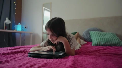 Little Girl Lying on Bed Using Digital Tablet Vidéo 343879314