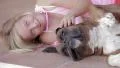 Little girl lying on side with her dog have fun HD Footage