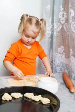 Little girl making dough in the kitchen. Stock-Fotos