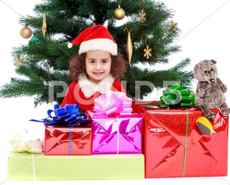 Little girl near the Christmas tree surrounded by gifts Stock Photos