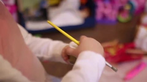 Little girl opens an empty can of paint Stock Footage 84764384