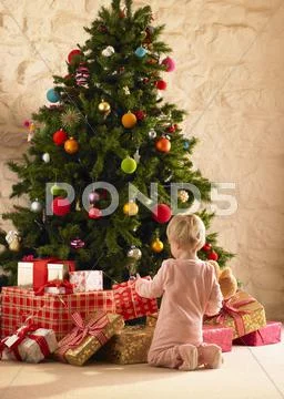 Little girl with parcels round christmas tree Stock Photos
