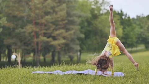 A little girl performs the elements of rhythmic gymnastics in the park. Stock Footage 183123757