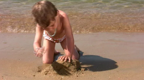 Little girl play with sand on beach | Stock Video | Pond5