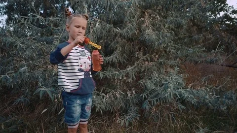 Little girl playing with bubble blower in the park Video stock 84865950