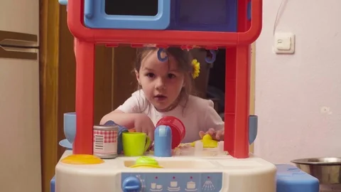 Little girl playing with dishes and food Stock Footage
