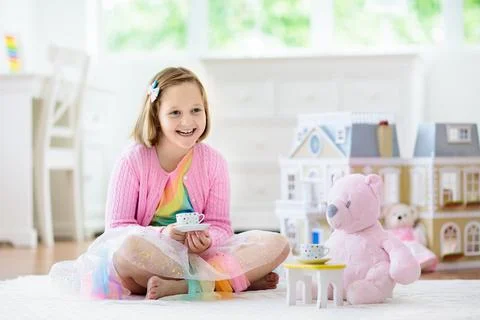 Little girl playing with doll house. Kid with toys Stock Photos