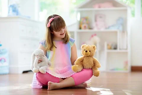 Little girl playing with doll house. Kid with toys Stock Photos