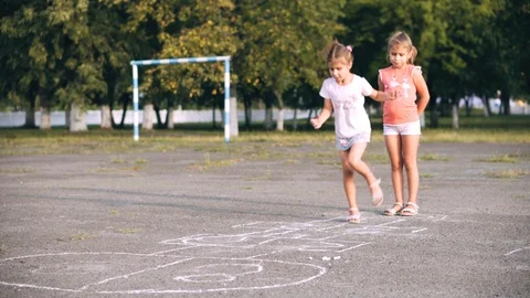 Little girl playing hopscotch at pre-school. Stock Footage