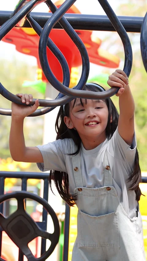 Little Girl Playing on Monkey Bars at Lumpini Park Bangkok Stock Footage 344944100