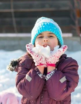 Little girl playing with snow Stock Photos