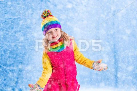 Little girl playing in snowy park Stock Photos