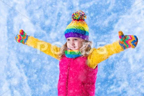 Little girl playing in snowy park Stock Photos