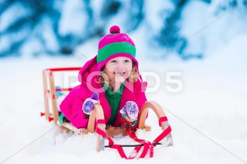 Little girl playing in snowy winter forest Stock Photos
