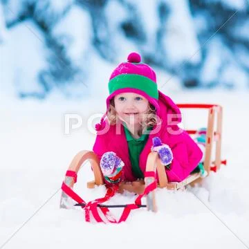 Little girl playing in snowy winter forest Stock Photos