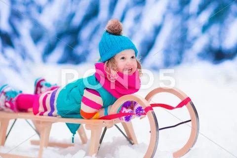 Little girl playing in snowy winter forest Stock Photos
