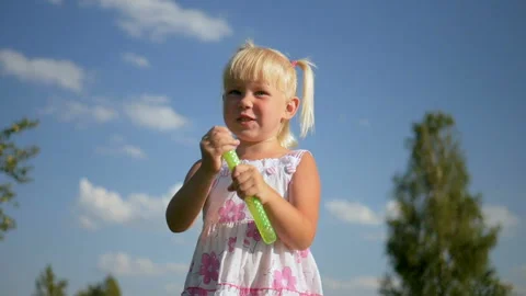 Little girl playing with soap bubbles outdoor Stock Footage